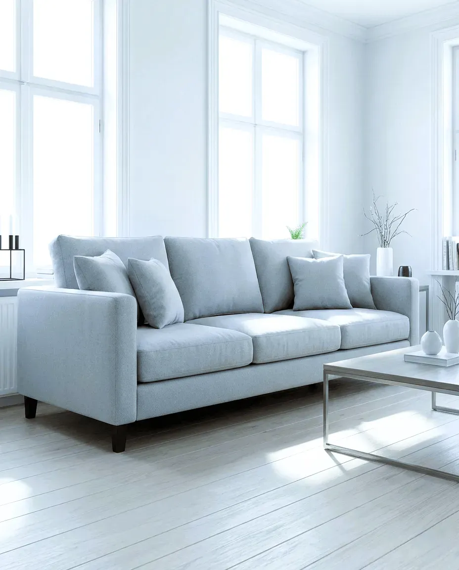 Sala de lujo con sofá gris de 3 puestos sobre piso de madera, luciendo impecable, seco y renovado tras el método exclusivo de limpieza JCaiza.