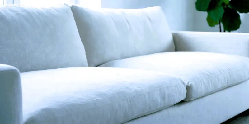 Sofá de lujo con tapicería blanca impecable y renovada tras servicio de lavado profundo y desmanchado profesional